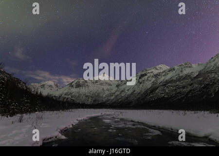 Aurora peinture couleurs diffuses le ciel nocturne au-dessus de l'aigle et l'ours polaire pics dans la vallée de la rivière Eagle dans le sud de l'Alaska. L'hiver. En soirée. Banque D'Images