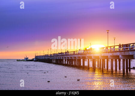 Piliers de béton armé station piétonne pier situé dans l'eau sur la côte de la mer Baltique. Péniche amarrée à passagers bridge au coucher du soleil en station Palanga, Li Banque D'Images