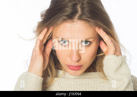 Jeune femme blonde grave hnads sur la tête fixant sur un fond blanc. Banque D'Images