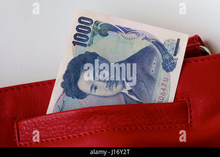 Yen japonais dans un sac en cuir rouge. Banque D'Images