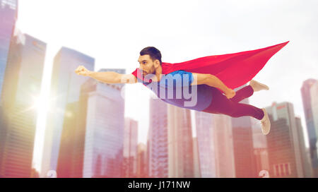L'homme en rouge cape de super-héros volant au-dessus de ville Banque D'Images