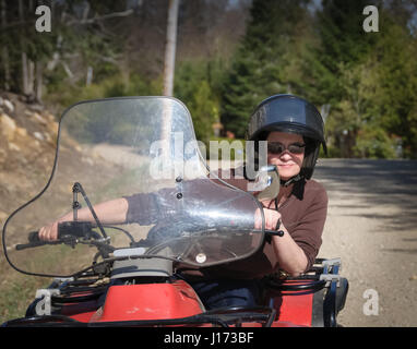 Jeune femme équitation un Quad au Québec rural road, Canada Banque D'Images