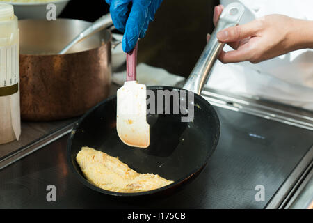 Chef omelette d'oeufs dans le plat au restaurant. Banque D'Images