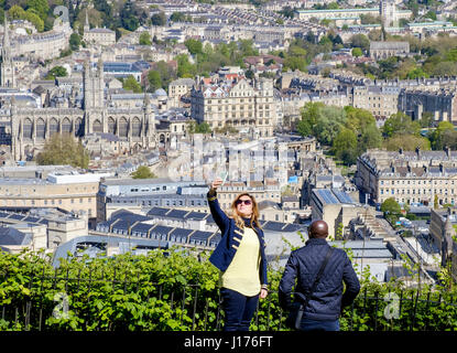 Bath, Royaume-Uni. 18 avr, 2017. Avec la ville de Bath derrière elle, une femme en profitant de la chaleur du soleil du printemps et un point de vue élevé est illustrée comme elle prend un en selfies Alexandra Park. Credit : lynchpics/Alamy Live News Banque D'Images