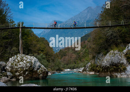 Les cyclistes de montagne monter un pont de bois sur la rivière Soca en Slovénie, l'Europe. Banque D'Images
