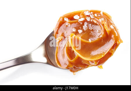 Cuillère à soupe de caramel au beurre salé fait maison douce isolé sur fond blanc, vue du dessus Banque D'Images