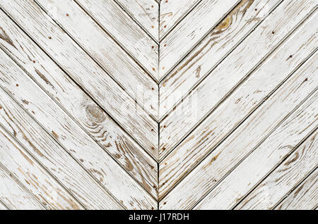 La texture de la vieille porte en bois qui est couvert de peinture blanche minable. Lignes obliques en miroir. Banque D'Images