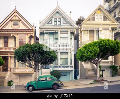 Un livre vert Volkswagen garée en face de la 'Painted Ladies' rangée de maisons victoriennes sur Steiner Street (à Alamo Square) à San Francisco. Banque D'Images