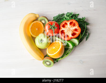 Coeur fait à partir de différents fruits et légumes sur la table en bois clair Banque D'Images