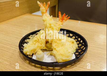 Crevettes tempura croustillante (crevettes frits) servi sur le panier noir et mis sur table en bois Banque D'Images