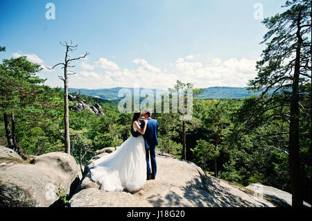 Joli couple de mariés à l'étonnant paysage avec rock Dovbush, montagnes des Carpates à l'Ukraine. Banque D'Images