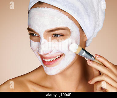 Femme avec masque facial apaisant. Close up of young woman sur fond beige. Procédures de beauté concept de soins de la peau Banque D'Images