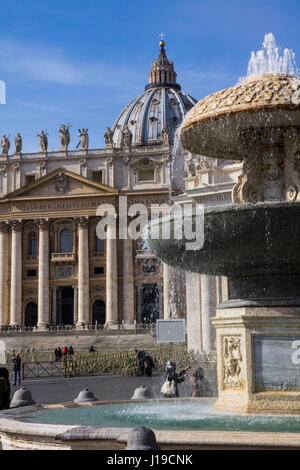 Une vue de la Basilique Saint Pierre, avec la fontaine en marbre 1613 de Carlo Maderno au premier plan, sur la Place Saint Pierre, Vatican, Rome, Italie. Banque D'Images