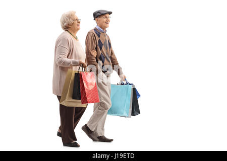 Profil de pleine longueur shot of a senior couple with shopping bags walking isolé sur fond blanc Banque D'Images