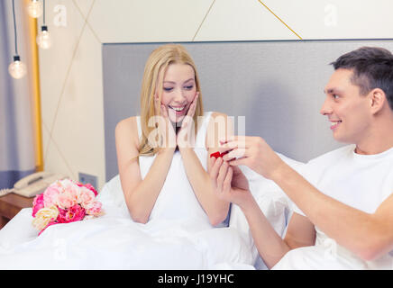 Man giving woman petite boîte rouge et anneau en C Banque D'Images