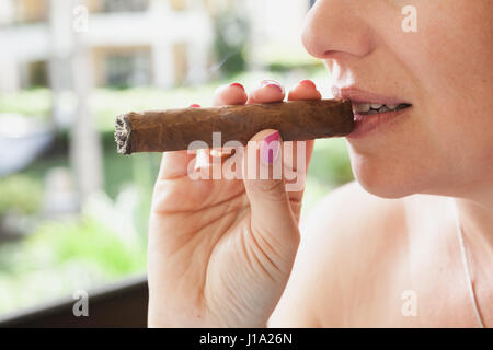 Jeune femme européenne fume le cigare à la main, photo gros plan avec focus sélectif. République Dominicaine Banque D'Images