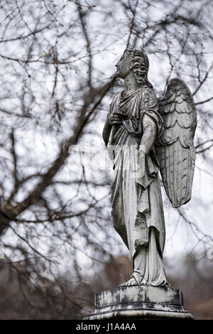 Ancienne sculpture de tombstone un ange avec bras cassé et les ailes sur le cimetière. Banque D'Images