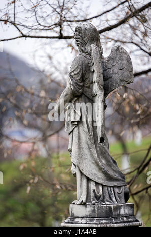 Ancienne sculpture de tombstone un ange avec bras cassé et les ailes sur le cimetière. Banque D'Images