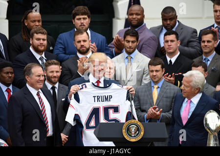 Washington D.C., USA. Apr 19, 2017. Le Président américain Donald Trump (C) reçoit un uniforme de l'équipe de New England Patriots lors d'une cérémonie d'accueil de la visite du Champion du Super Bowl New England Patriots sur la pelouse Sud de la Maison Blanche à Washington, DC, États-Unis, le 19 avril 2017. Credit : Yin Bogu/Xinhua/Alamy Live News Banque D'Images