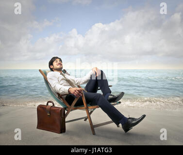 Businessman resting on the beach Banque D'Images