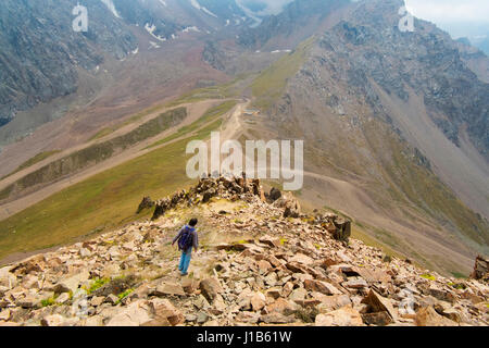 Caucasian man randonnées sur les roches de montagne Banque D'Images