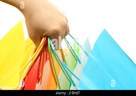 La main d'une femme portant un tas de colorful shopping bags Banque D'Images