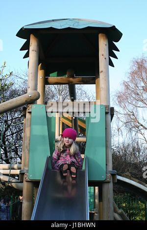 Petite fille enfant descendant le toboggan, jouant dans l'aire de jeux, St Stephen's Green, Dublin Irlande Banque D'Images