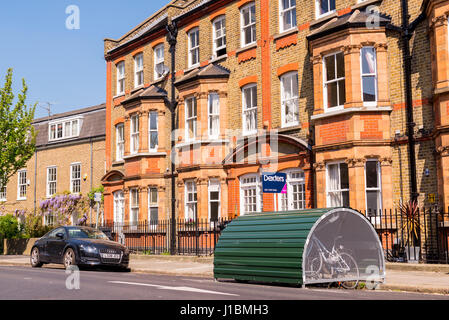 Rue britannique classique Victorien restauré avec des maisons de brique sur une route locale iin Lambeth avec green à vélos à côté de la chaussée. Londres, Royaume-Uni. Banque D'Images