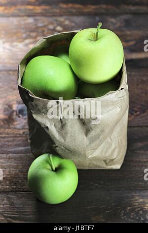 Les pommes (variété Delcorf) dans un sac de papier sur fond de bois Banque D'Images