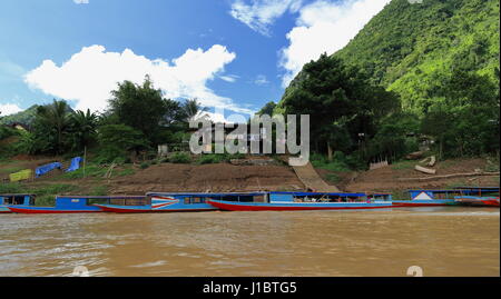 Rivière Nam Ou, Laos-October 9, 2015 : Local slowboats naviguer la rivière servant comme principaux moyens de transport en l'absence de routes terrestres. Bateaux touristiques moor Banque D'Images