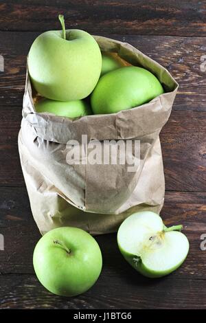 Les pommes (variété Delcorf) dans un sac de papier sur fond de bois Banque D'Images