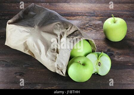 Les pommes (variété Delcorf) dans un sac de papier sur fond de bois Banque D'Images