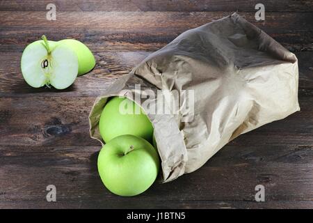 Les pommes (variété Delcorf) dans un sac de papier sur fond de bois Banque D'Images