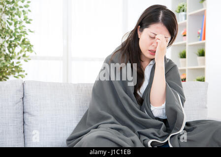 Portrait d'une femme malade se sentir mal de tête sur un canapé. Femme Prise Cold and Flu. de la médecine et de la santé. concept de race mixte modèle chinois asiatique Banque D'Images