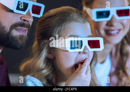 Close-up view of family portant des lunettes 3d et regarder la vidéo eating popcorn Banque D'Images