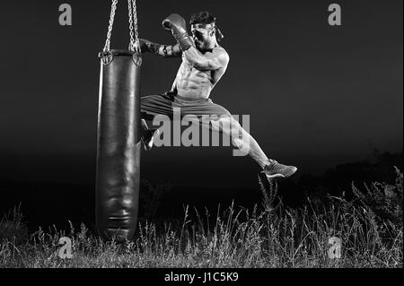 Plans d'un monochrome male boxer formation avec un sac de boxe ou Banque D'Images