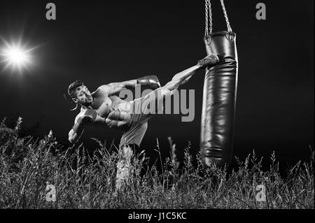 Plans d'un monochrome male boxer formation avec un sac de boxe ou Banque D'Images