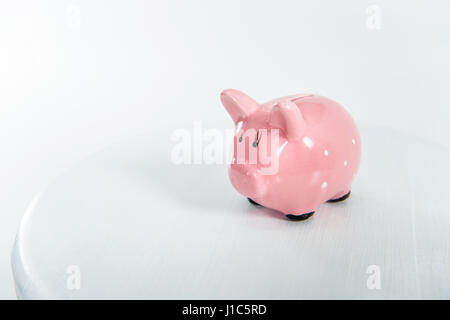 Little pink piggy bank debout sur white with copy space Banque D'Images