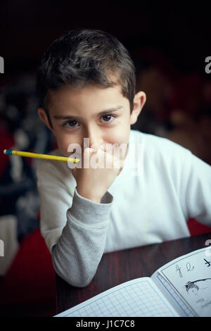 Smiling Hispanic boy practicing alphabet écriture Banque D'Images