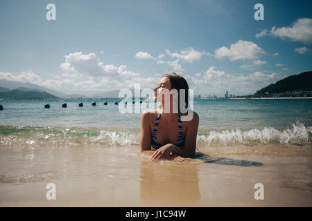 Caucasian woman wearing bikini fixant dans les vagues sur la plage Banque D'Images