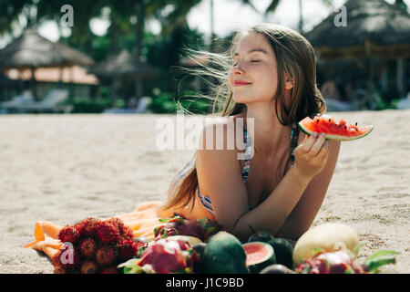 Eating watermelon woman on beach Banque D'Images