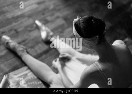 Woman sitting on floor portant des chaussures de ballet Banque D'Images