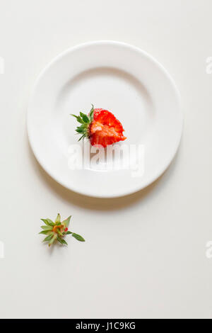 Mordu strawberry on white plate Banque D'Images