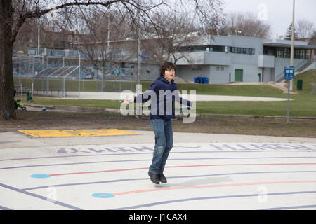 Dix ans SAUTE SUR LA CORDE DE PRINTEMPS CHAUD JOURNÉE AU PARC CHRISTIE PITS À TORONTO, AU CANADA. Banque D'Images