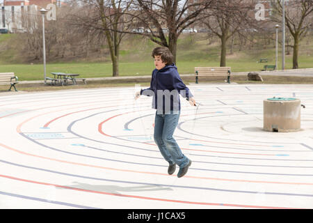 Dix ans SAUTE SUR LA CORDE DE PRINTEMPS CHAUD JOURNÉE AU PARC CHRISTIE PITS À TORONTO, AU CANADA. Banque D'Images