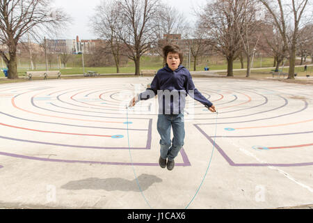 Dix ans SAUTE SUR LA CORDE DE PRINTEMPS CHAUD JOURNÉE AU PARC CHRISTIE PITS À TORONTO, AU CANADA. Banque D'Images