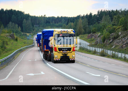 Mikkeli, Finlande - septembre 1, 2016 : Yellow MAN V8 semi truck de Silvasti mène le convoi de transport routier charge large dans la soirée le long scenic Banque D'Images