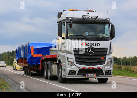 Mikkeli, Finlande - septembre 1, 2016 : Argent Mercedes-Benz Actros 3351 semi truck tire charge large accompagnée d'un véhicule d'escorte dans le centre de la Finlande. Banque D'Images