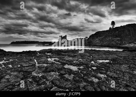 Rock formation côtières près de plage de Bombo Kiama littoral du Pacifique au coucher du soleil. Les roches de grès célèbre Cathédrale convertis en noir-blanc. Banque D'Images