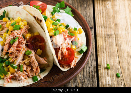 Taco Poulet Mijoteuse fait maison avec le maïs servi sur une plaque en céramique rustique sur table en bois, style mexicain Banque D'Images